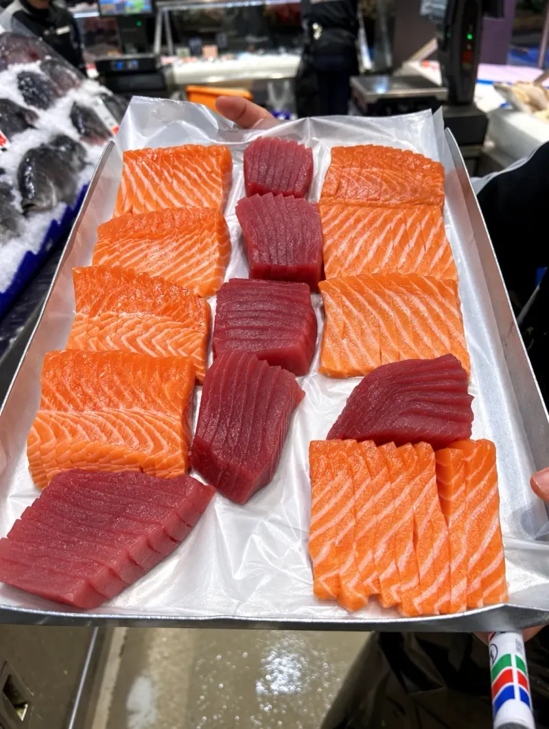 Freshly sliced salmon and tuna sashimi laid out on a tray
